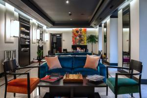 a living room with a blue couch and a table at 47 Boutique Hotel in Rome