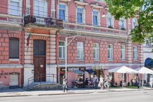 pessoas andando em uma rua em frente a um edifício em Sodu15 Apartments em Vilnius