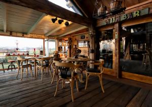 un restaurante con suelo de madera, mesas y sillas en Guesthouse Ensenada en Schoondijke