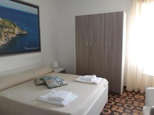 una camera da letto con un letto e due asciugamani di Hotel Rosy a Battipaglia