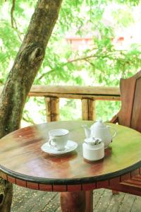 un tavolo di legno con tazze e teiere sopra di La Pentera a Hambegamuwa