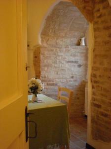 Una habitación con una mesa con un jarrón de flores. en Il Castello Di Dante, en Falconara Marittima