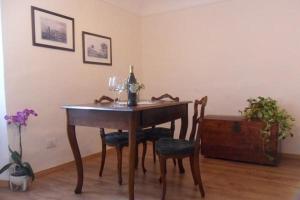 a dining room table with two chairs and a bottle of wine at Il Castello Di Dante in Falconara Marittima