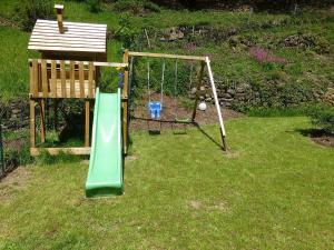 a playground with a slide and a swing at Ferienhaus Froschkönig in Oberharmersbach