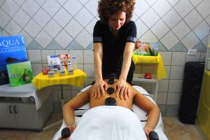 Una donna che riceve un massaggio da un uomo in un salone di Hotel Castiglione a Ischia
