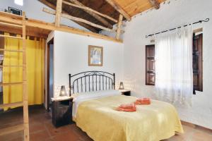 Un dormitorio con una cama con toallas rojas. en Casa Rural Ahora, en El Colmenar