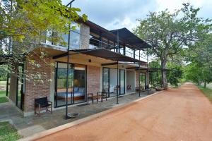 an external view of a brick house with glass windows at Kalundewa Retreat in Dambulla