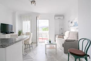 eine Küche und ein Wohnzimmer mit Sofa und Tisch in der Unterkunft Estela Maris in Nerja