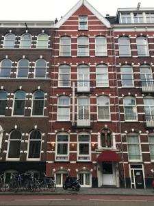 budynek z czerwonej cegły z rowerami zaparkowanymi przed nim w obiekcie Hotel Sphinx w Amsterdamie