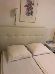 a bed with a white comforter and pillows on it at Budget Hostel Sphinx in Amsterdam