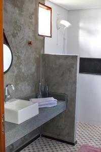 a bathroom with a sink and a counter with a mirror at Casa da Massagueira-AL in Marechal Deodoro
