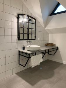 Un baño blanco con lavabo y espejo. en Folwark Wąsowo, en Wąsowo