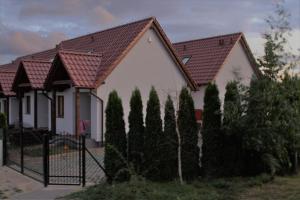 a house with a fence and trees in front of it at WCZASOWISKO TOLKOWO in Jarosławiec