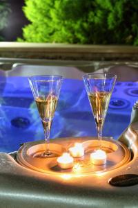 two wine glasses sitting on a tray with candles at Arhontika Villas in Élos