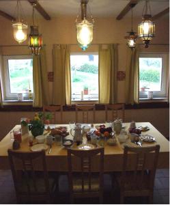 einen Esstisch mit Essen und Fenstern in der Unterkunft Hof-Solgaard in Loit