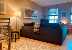 a living room with a blue couch and a mirror at The Webstersland Residence in Edinburgh