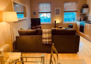 a living room with a couch and a kitchen at The Webstersland Residence in Edinburgh