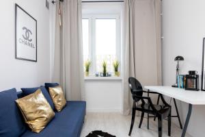 een woonkamer met een blauwe bank en een tafel bij Stara Ochota Vogue Apartment in Warschau