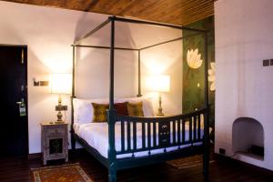a bedroom with a canopy bed with two lamps at The Temi Bungalow South Sikkim in Namchi