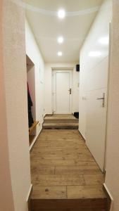 a long hallway with a white door and wooden floors at apartmán U Moravy in Olomouc