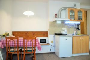una cucina con tavolo, sedie e frigorifero di Privat NIKA a Závažná Poruba
