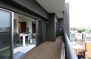 a balcony with a table and a view of a city at A.T. Hotel Hakata in Fukuoka