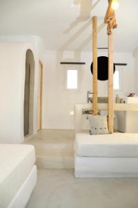 Cette chambre blanche comprend deux lits et une table. dans l'établissement Irida Vacation suites, à Kastraki Naxou