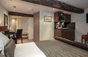 1 dormitorio con 1 cama y cocina con microondas en Bagshaw Hall en Bakewell