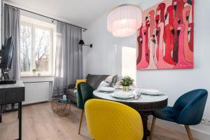 a living room with a dining room table and chairs at Dobra 87 by Homeprime in Warsaw