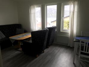 una sala da pranzo con tavolo, sedie e finestra di Fjordgård B a Tofta