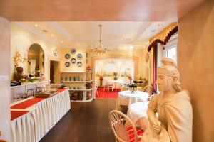 a restaurant with a statue of a woman in a room at Hotel Modena in Bad Steben