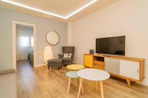 ein Wohnzimmer mit Fernseher und Tisch in der Unterkunft Bright apartment near Casa de Campo by Batuecas in Madrid