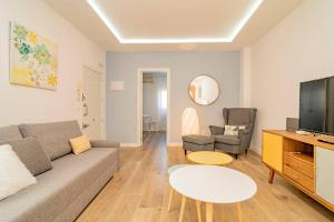 ein Wohnzimmer mit Couch und Fernseher in der Unterkunft Bright apartment near Casa de Campo by Batuecas in Madrid