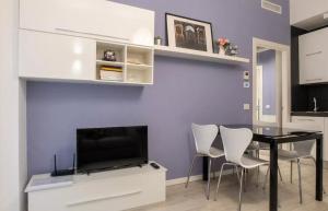 een eetkamer met een tafel en een tv bij Modern apartment in Milan in Milaan