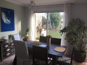 uma sala de jantar com uma mesa de madeira e uma janela em Maison Chevreuse, chambre chez l'habitant em Magny-les-Hameaux