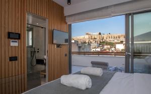 a bedroom with a bed and a view of the city at Acropolis Golden Suites by GHH in Athens +116 photos