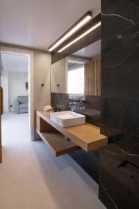 a bathroom with a sink and a large mirror at Acropolis Golden Suites by GHH in Athens