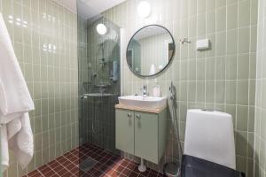 y baño con lavabo y espejo. en Forenom Aparthotel Jyväskylä, en Jyväskylä