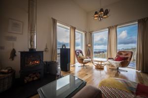 a living room with a fireplace and a couch and chairs at Salt Winds in Stein