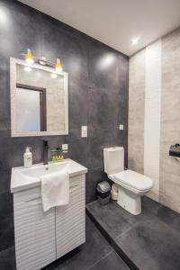 W łazience znajduje się toaleta, umywalka i lustro. w obiekcie Modern Apartments on Baseina near Arena City w Kijowie