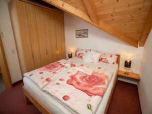 ein Schlafzimmer mit einem Bett mit Blumen darauf in der Unterkunft Landhaus Wanger in Pfronten