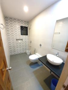 a bathroom with two sinks and a toilet at Casa de Laura in Calangute