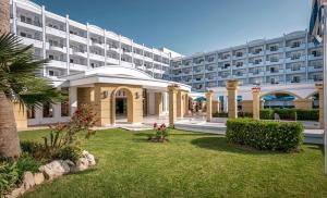 
a large white building with a lawn chair in front of it at Mitsis Grand Hotel Beach Hotel in Rhodes Town
