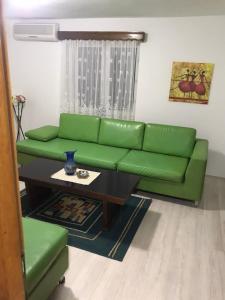 een woonkamer met een groene bank en een tafel bij Lydia Center Apartment in Veles