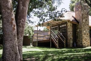 a building with a wooden staircase next to some trees at Breathe River Retreat in Parys