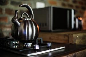 a metal tea kettle sitting on top of a stove at Breathe River Retreat in Parys