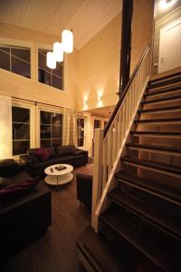 a living room with a staircase and a couch at Himos Villa Nummenranta 2 in Säyrylä