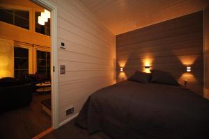 a bedroom with a bed with two lights on it at Himos Villa Nummenranta 2 in Säyrylä
