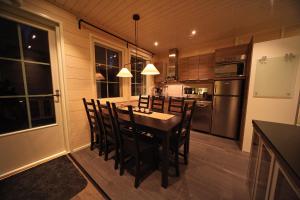 a kitchen with a table and chairs in it at Himos Villa Nummenranta 2 in Säyrylä