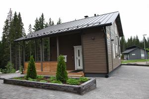 a small house with a roof on a patio at Himos Villa Nummenranta 2 in Säyrylä